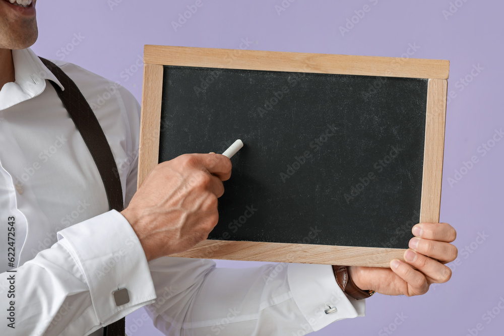 Male teacher with chalkboard on lilac background, closeup