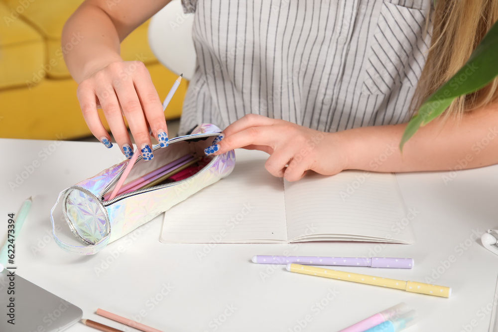 Female student with pencil case at table, closeup