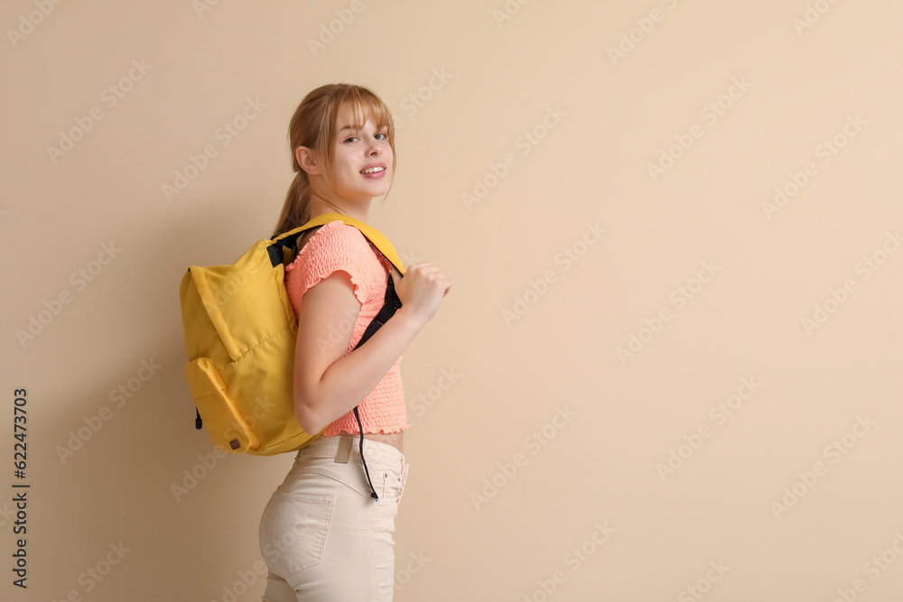 Female student with backpack on beige background