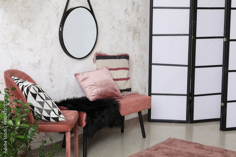 Interior of living room with chair, bench and mirror