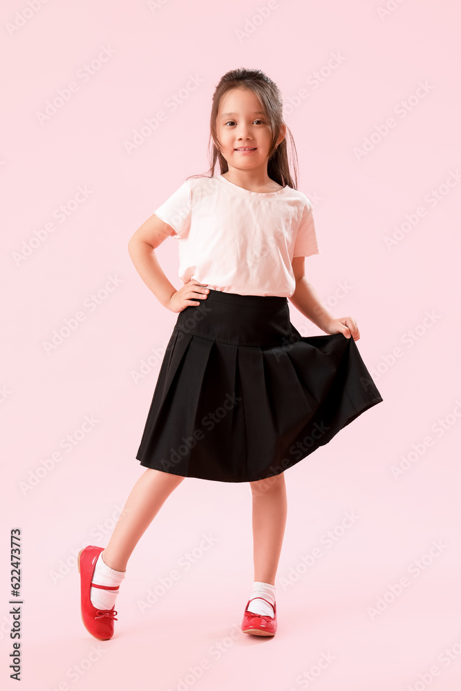 Little schoolgirl on pink background