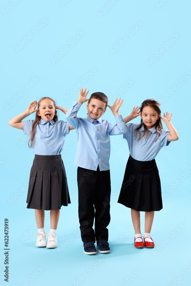 Funny little schoolchildren on light blue background