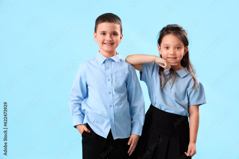 Little schoolchildren on light blue background