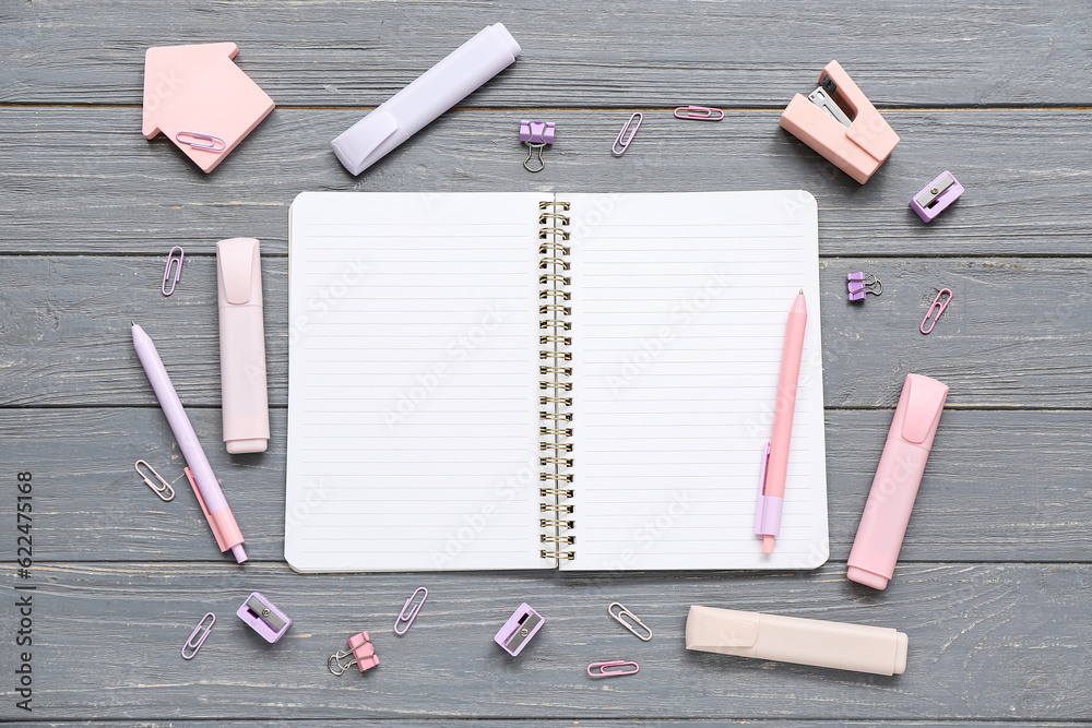 Blank notebook with different stationery on grey wooden background