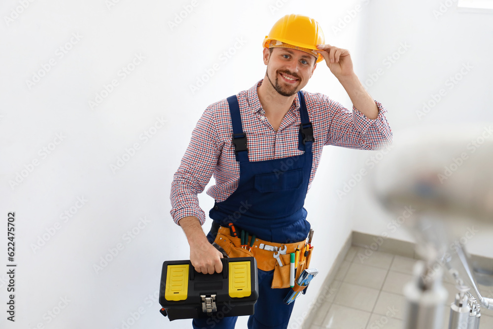 Male builder with tool bag in stairway