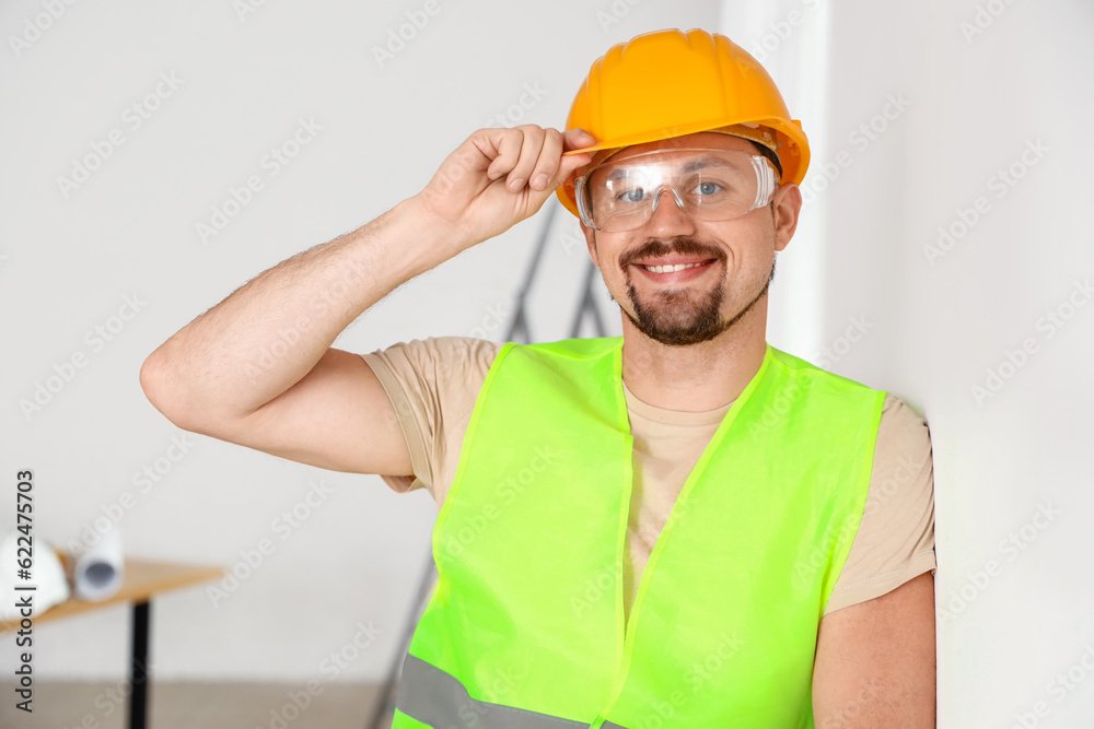 Male builder working in room