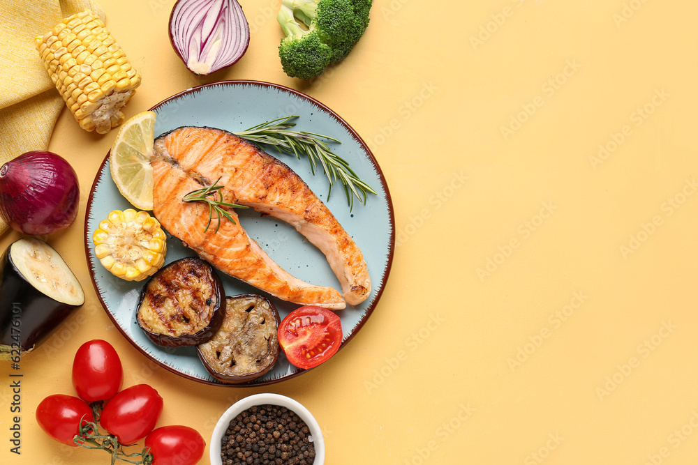 Plate with tasty grilled salmon steak and vegetables on yellow background