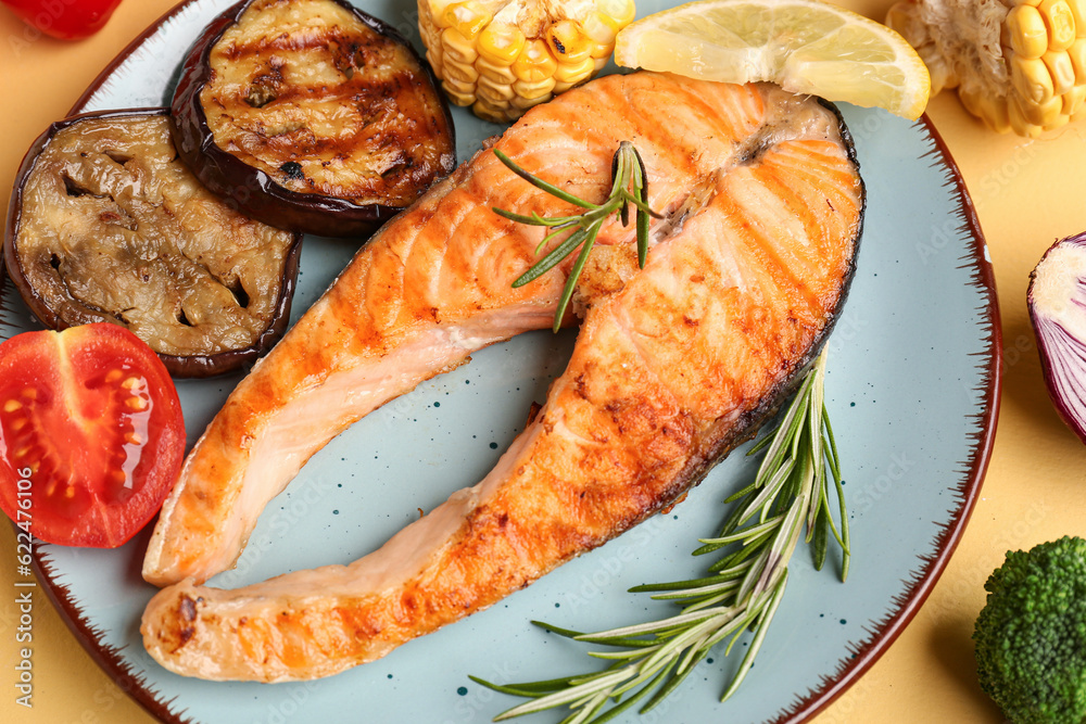 Plate with tasty grilled salmon steak and vegetables on table