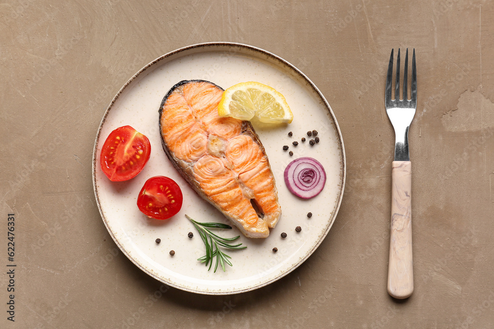 Plate with tasty grilled salmon steak on beige background