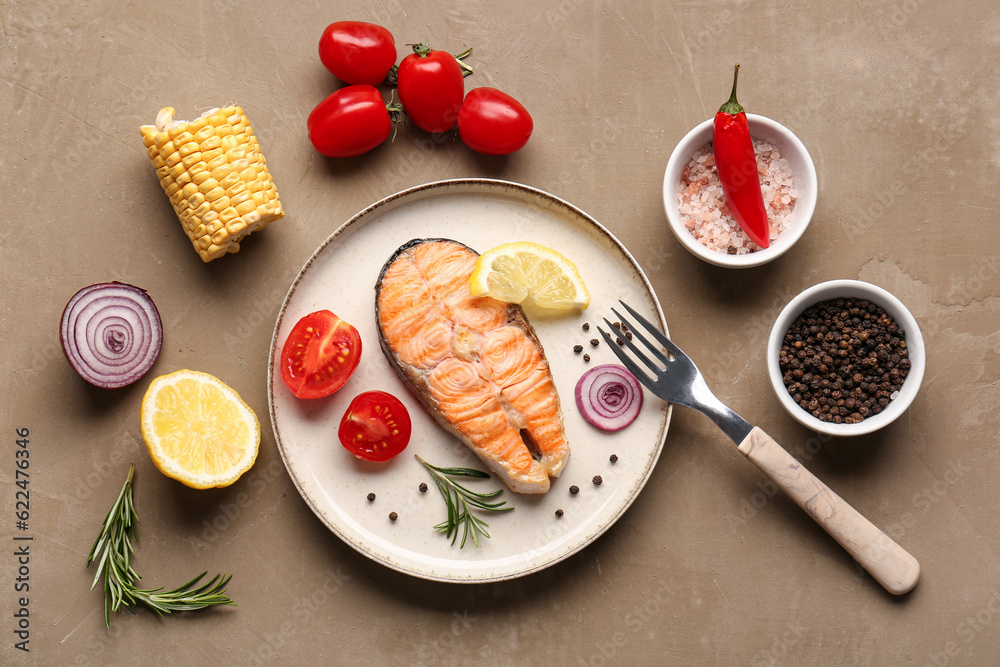 Plate with tasty grilled salmon steak and vegetables on beige background