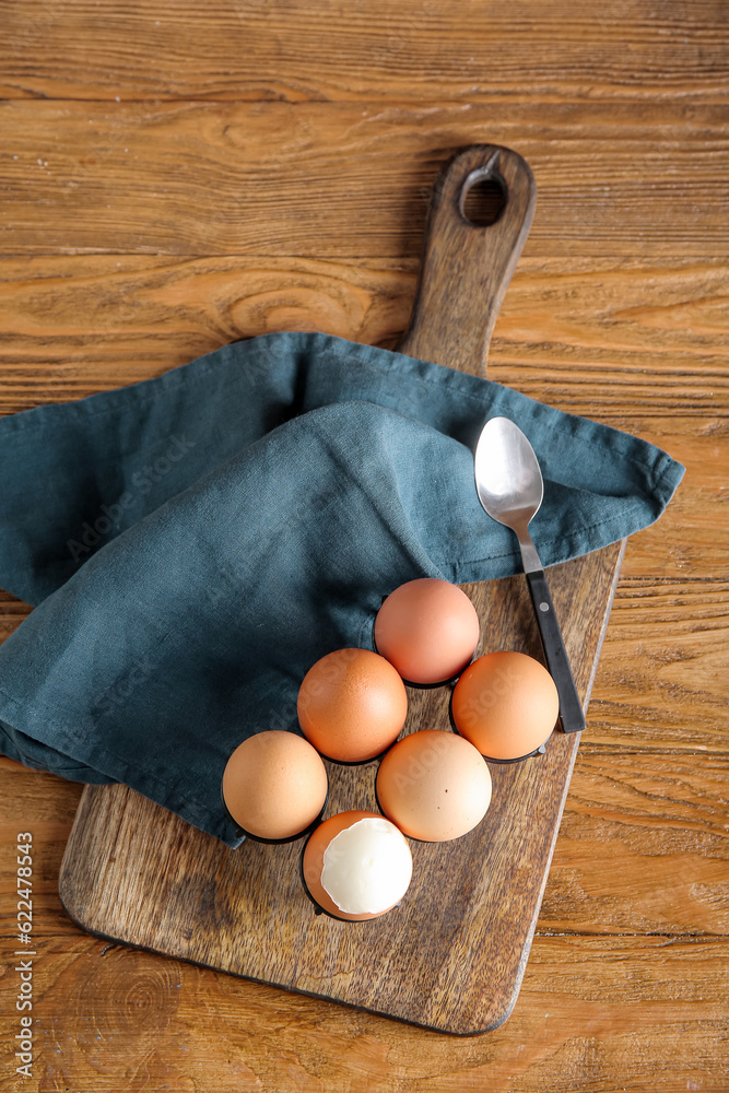 Holder with boiled chicken eggs on wooden background