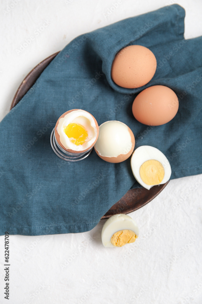 Plate with boiled chicken eggs on white background