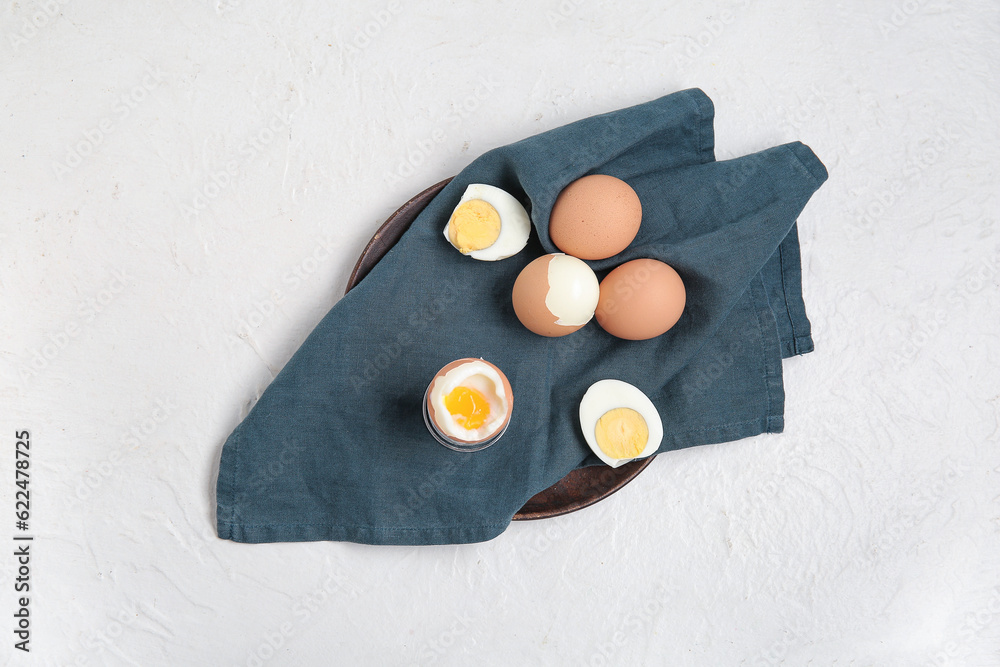 Plate with boiled chicken eggs on white background