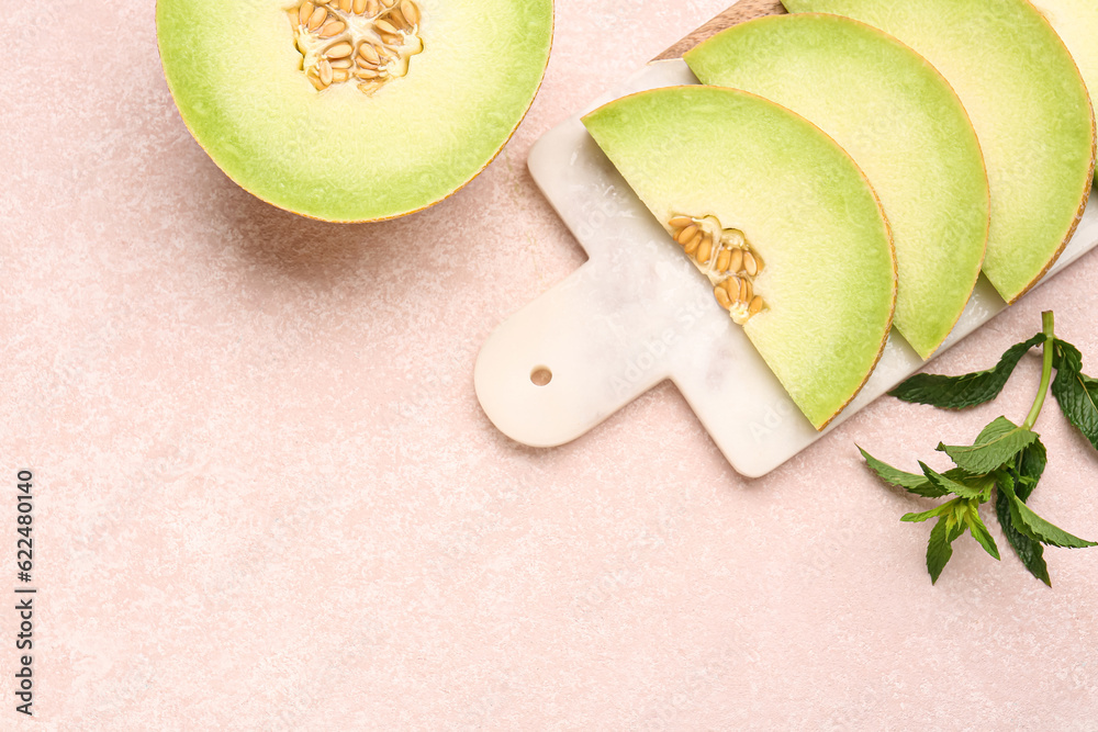 Half of sweet melon and board with pieces on pink background