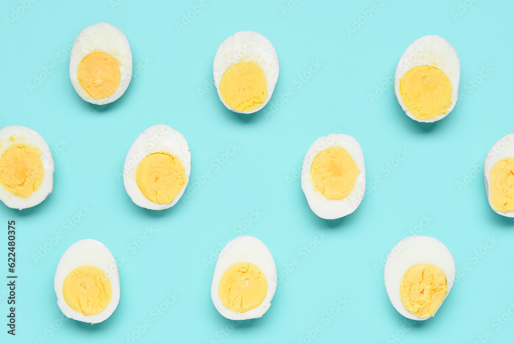 Halves of tasty boiled eggs on blue background