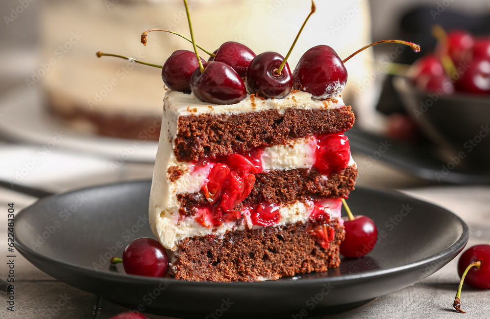 Plate with piece of tasty cherry cake on table