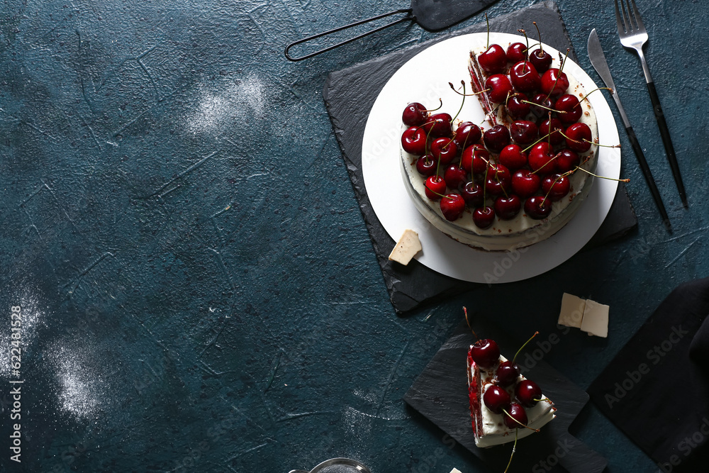 Boards with tasty cherry cake on blue background