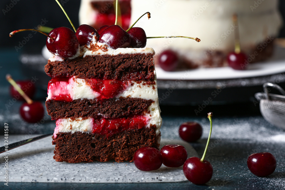 Board with piece of tasty cherry cake on table