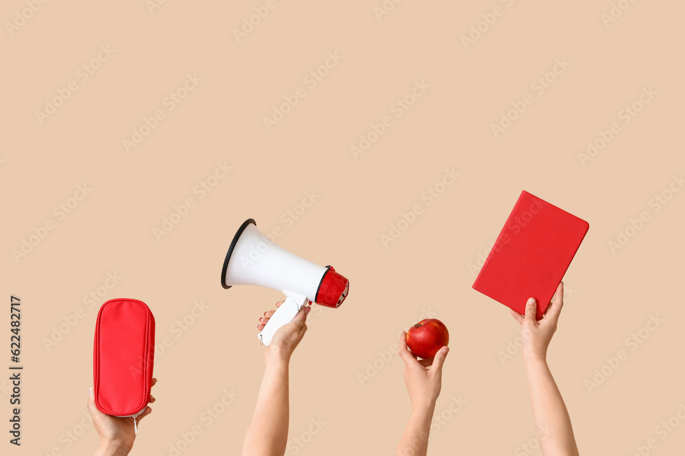 Female hands holding school supplies on beige background