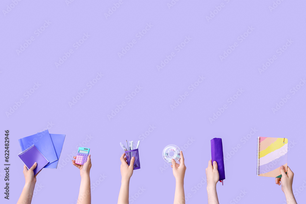 Many hands holding school supplies on lilac background