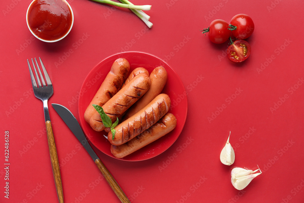 Plate with tasty grilled sausages and sauce on red background