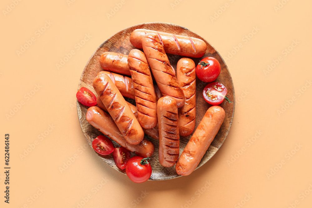 Plate with tasty grilled sausages on orange background