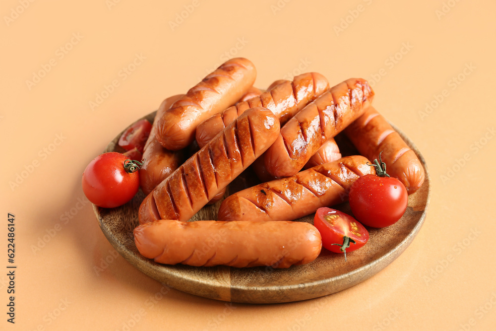 Plate with tasty grilled sausages on orange background