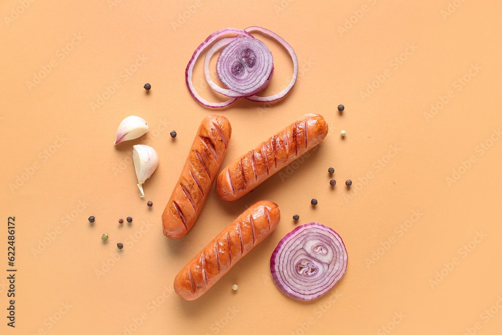 Tasty grilled sausages on orange background