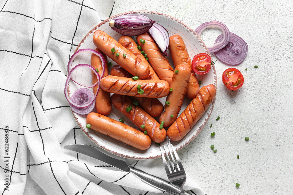 Plate with tasty grilled sausages on light background