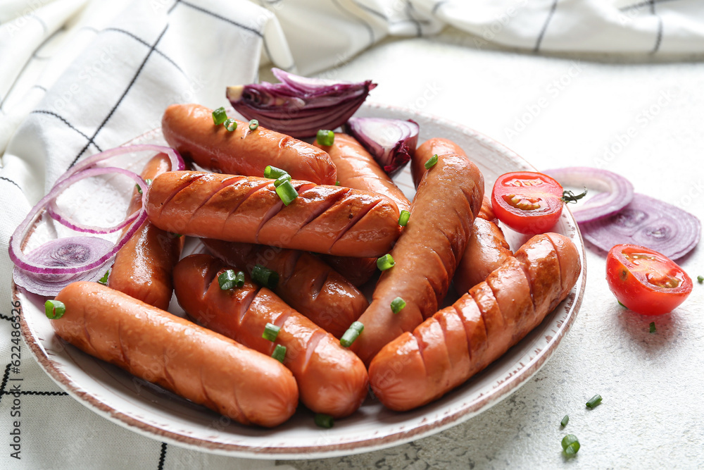 Plate with tasty grilled sausages on light background