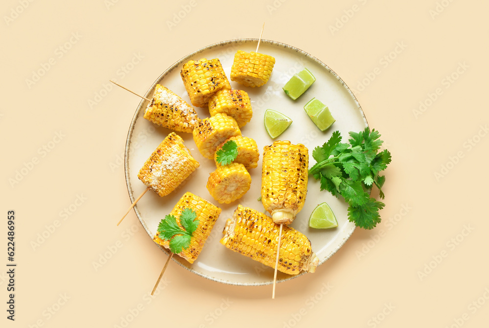 Plate with cut tasty grilled corn cobs and parsley on yellow background