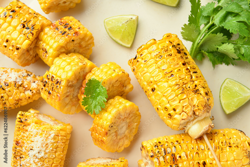 Cut tasty grilled corn cobs and parsley on light background