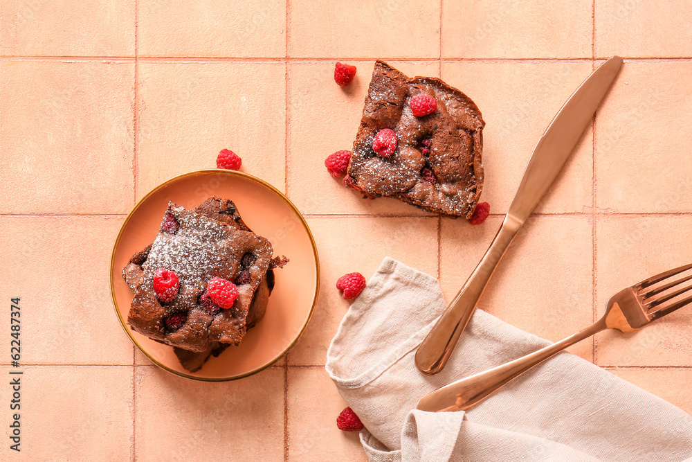 Plate with pieces of raspberry chocolate brownie on pink tile table