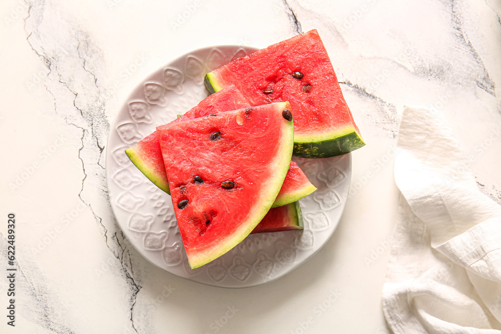 Plate with pieces of fresh watermelon on white table