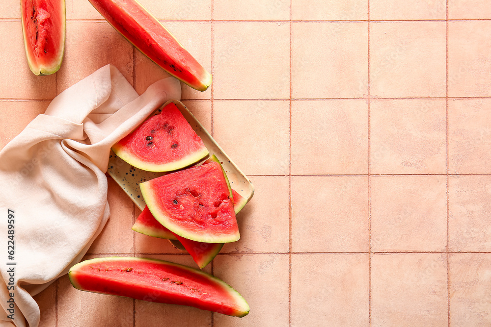 Pieces of fresh watermelon on pink tile table