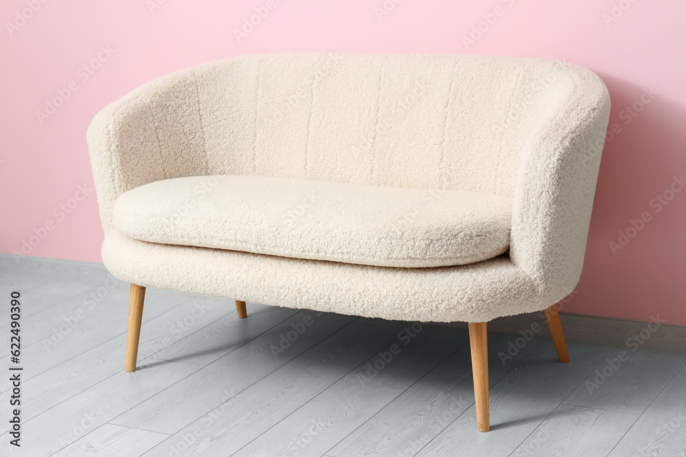 Cozy white sofa near pink wall