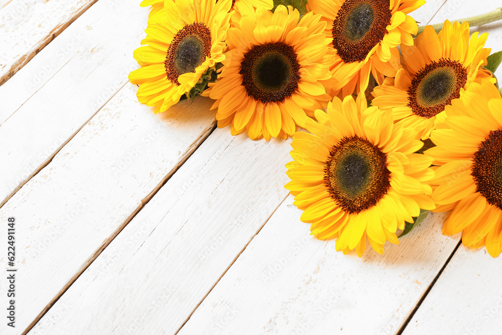 Beautiful sunflowers on white wooden background