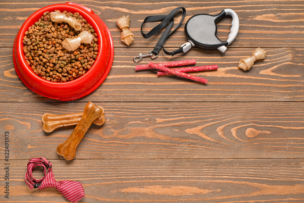 Set of dog food with accessories on wooden background