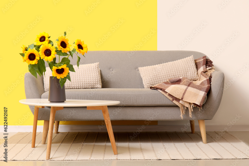 Vase with sunflowers on table in living room