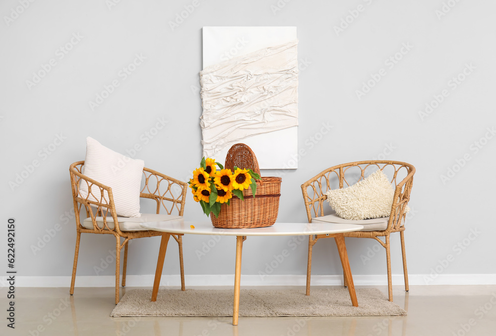 Wicker basket with sunflowers on table in dining room