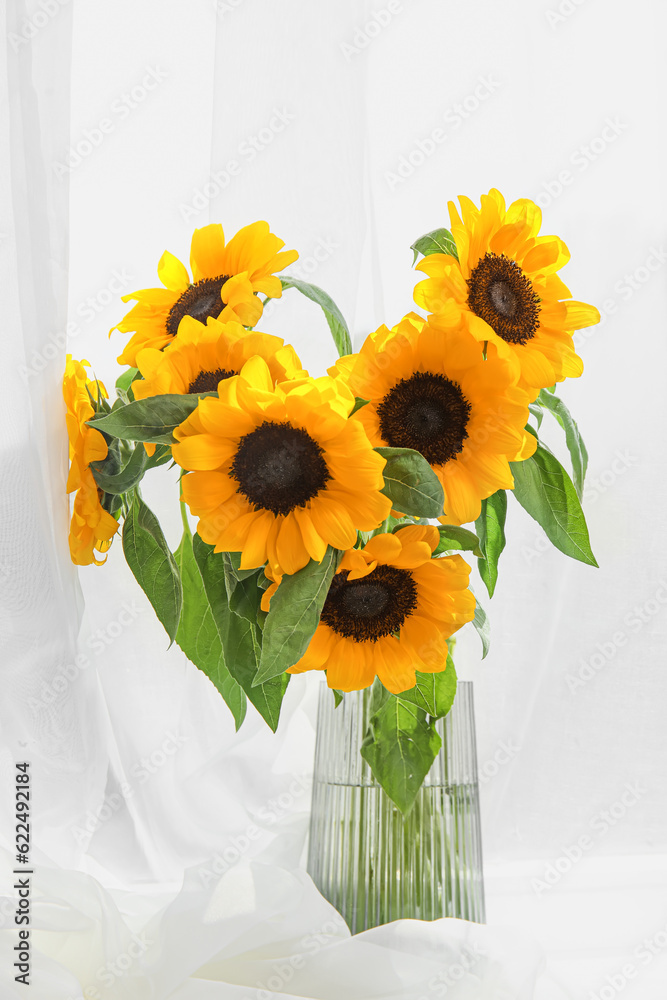 Vase with sunflowers on windowsill in room