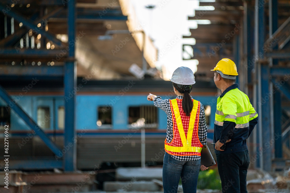 A team of engineers stand at the actual site to inspect and analyze the unfinished railway station c