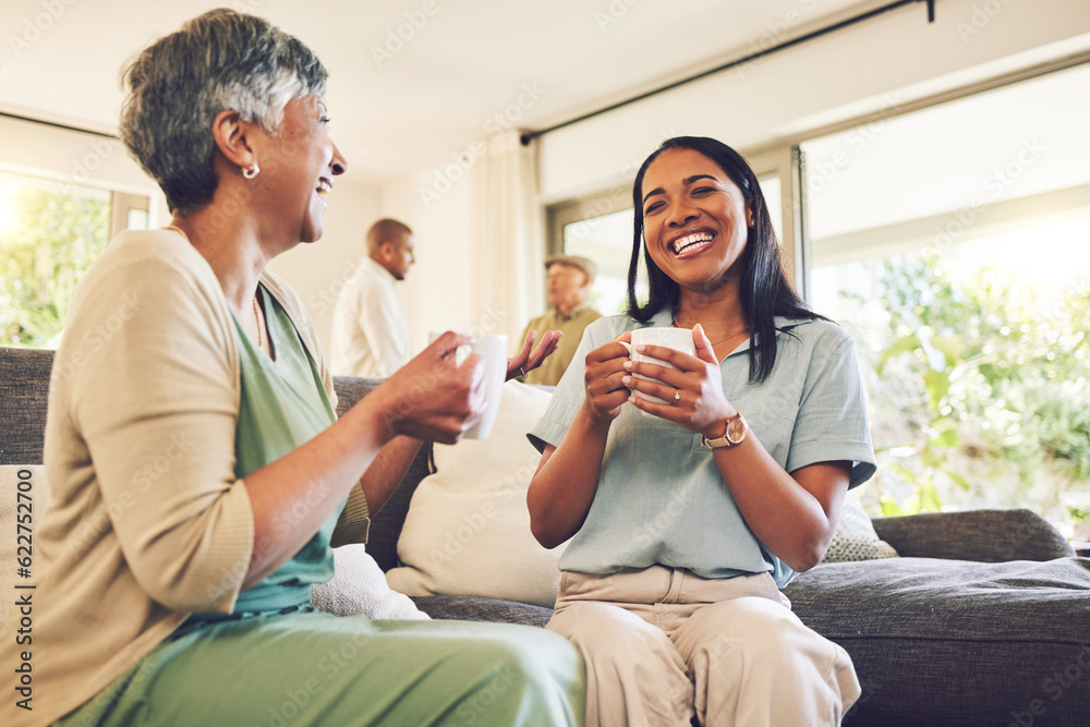 Woman drinking a cup of coffee with her senior mother while laughing, talking and bonding at home. H