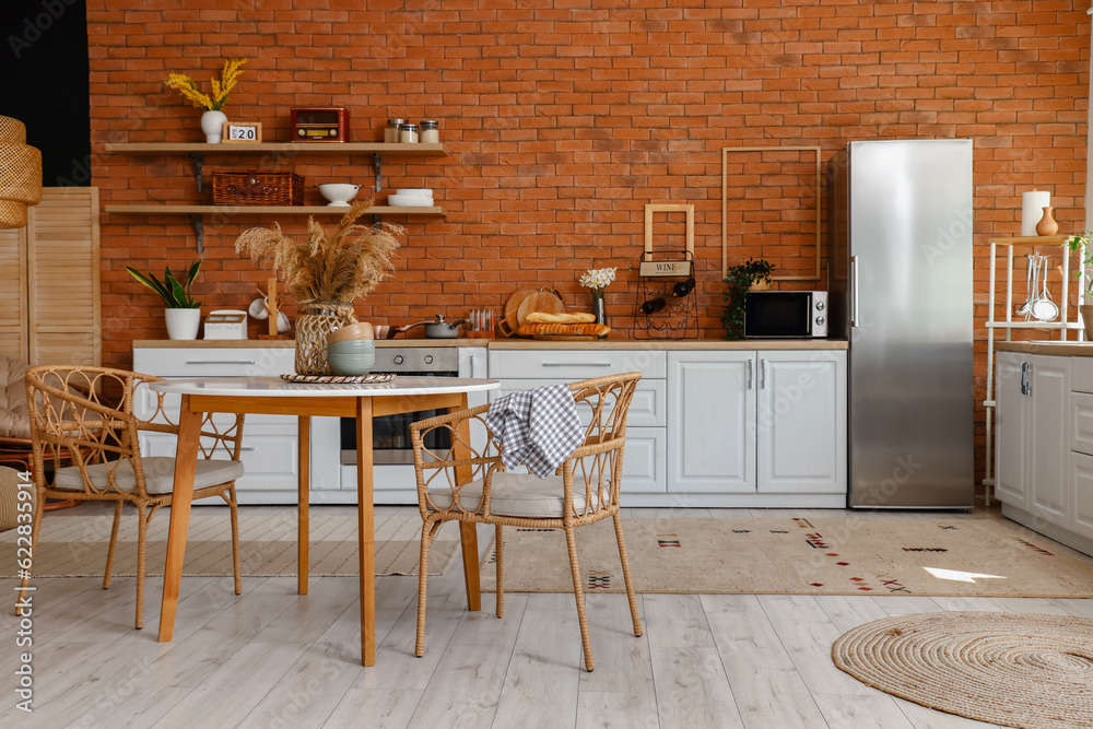 Interior of kitchen with stylish fridge, counters, shelves, table and chairs