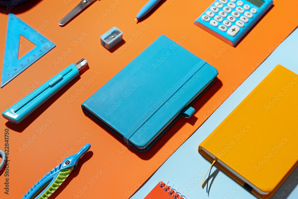 Set of notebooks and different school stationery on color background, closeup