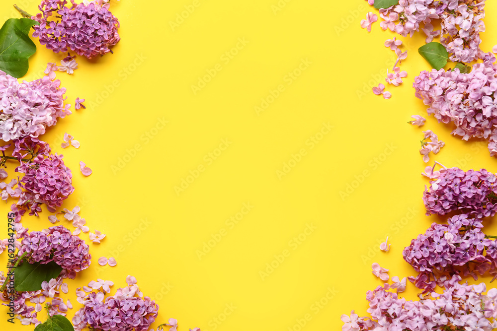 Frame made of beautiful lilac flowers on yellow background