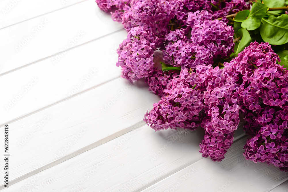 Beautiful lilac flowers on light wooden background, closeup