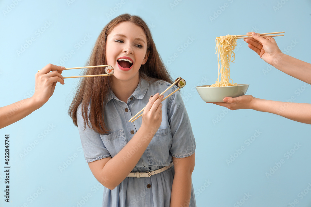 Young woman and female hands with Asian food on blue background