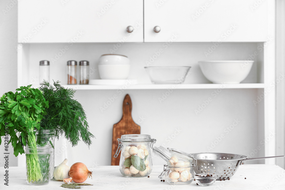 Jar with mushrooms for preservation on table in kitchen