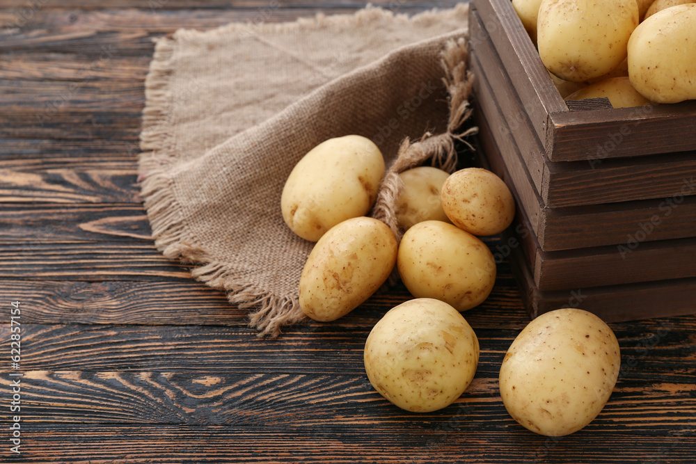 Raw potatoes on wooden background